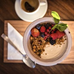 High angle view of fresh fruit, yogurt and coffe on table