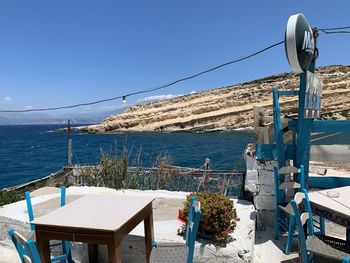 Built structure by sea against clear blue sky