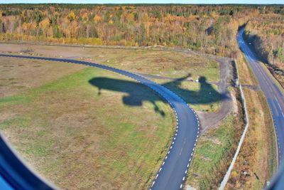 High angle view of road amidst trees on field