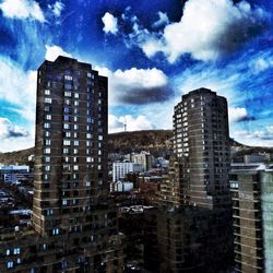 Low angle view of buildings against cloudy sky