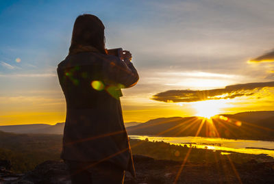 Man standing on mountain during sunset