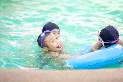 Rear view of girl swimming in pool