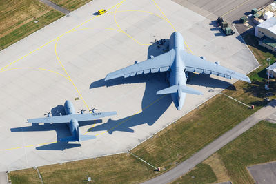 High angle view of airplane flying over airport runway