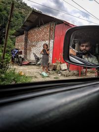 Reflection of woman on car mirror