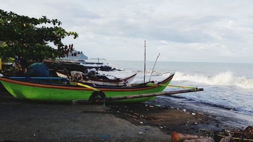 Boats moored on beach against sky