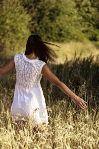 Rear view of woman standing on field