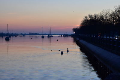 Silhouette man on boat against sky during sunset