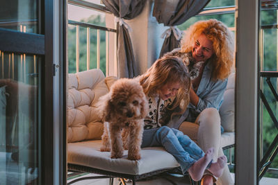 Happy child with smile plays on summer at home with mom, dog at sunset. cat, dog, pets family member