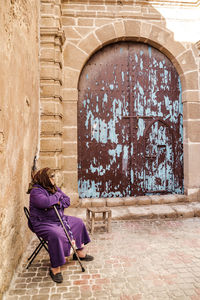 Woman standing against building wall