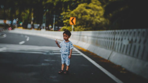 Full length of boy standing on road