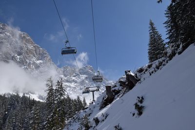 Overhead cable car over snowcapped mountains against sky