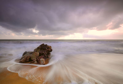 Rocks on beach against sky
