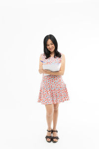 Portrait of woman standing against white background