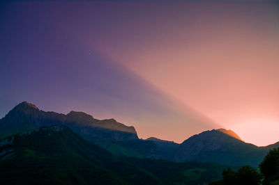 Scenic view of silhouette mountains against sky at sunset