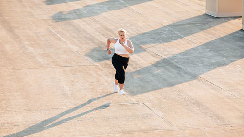 High angle view of woman with arms raised