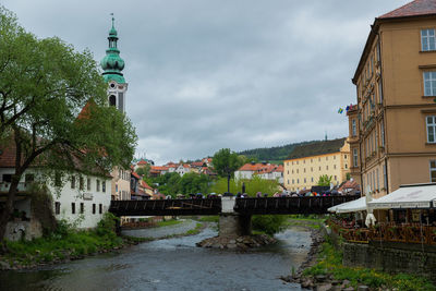 Canal amidst buildings against sky in city