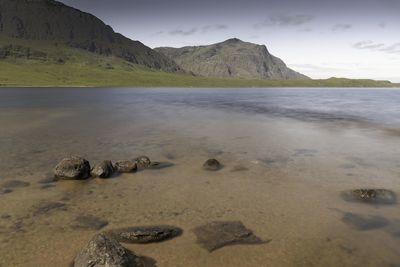 Scenic view of sea and mountains against sky