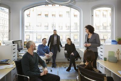 Male and female business professionals discussing in meeting at office