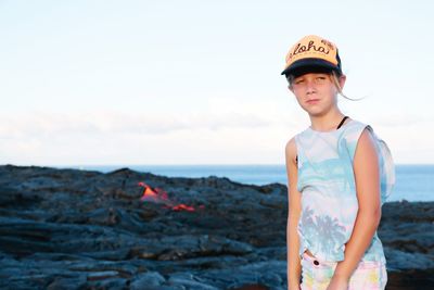 Portrait of boy standing on land against sky