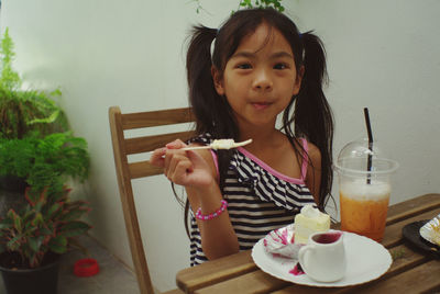 Portrait of cute girl sitting on table