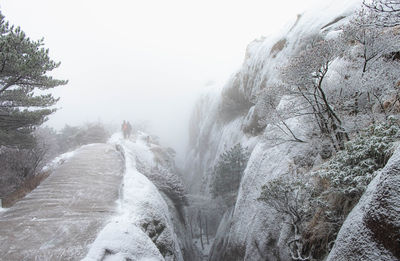 Scenic view of waterfall in foggy weather