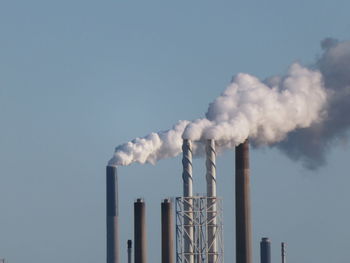 Smoke emitting from chimney against sky