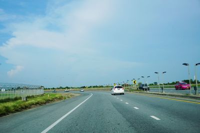 Vehicles on road against sky