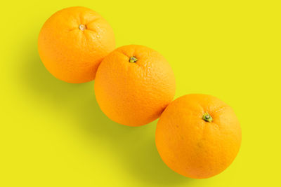 Close-up of orange fruit against yellow background