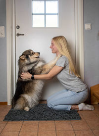 Portrait of young woman with dog at home