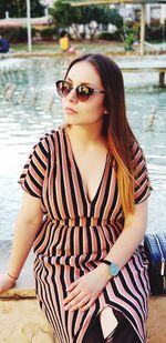Young woman wearing sunglasses sitting outdoors