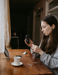 Young woman using mobile phone at home