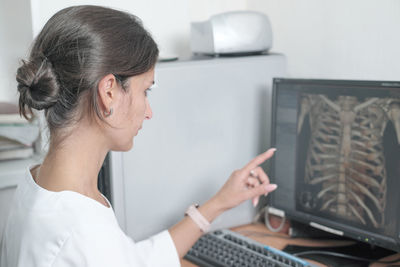 Woman doctor looking at monitor with chest bones computer tomography image. female radiologist