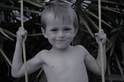 Portrait of cute boy sitting on swing