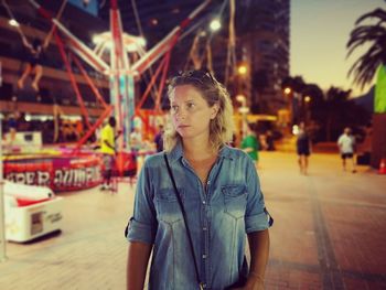 Portrait of young woman standing in city