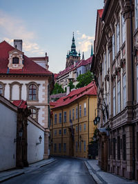 Road amidst buildings in town against sky