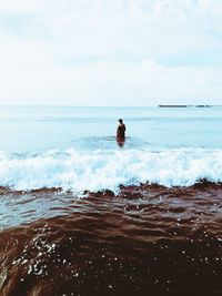 Man in sea against sky