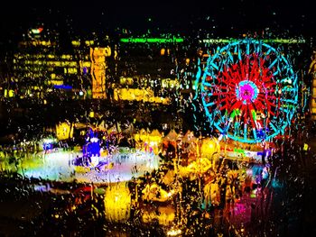 Illuminated ferris wheel in city at night