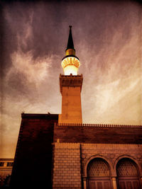 Low angle view of clock tower against cloudy sky