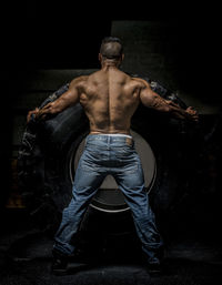 Body builder exercising with heavy tire