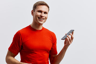 Young man using mobile phone against white background