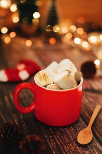 A cup of hot chocolate with marshmallows on wooden table, christmas drink on festive background 