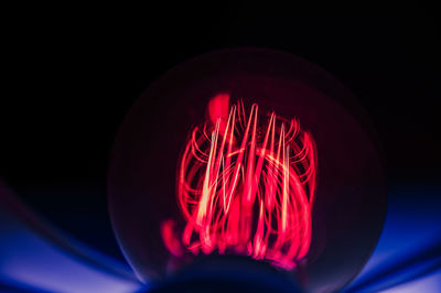 Close-up of illuminated lighting equipment in darkroom