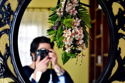 Portrait of woman photographing flowers