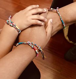 Cropped image of friends stacking hands over on table