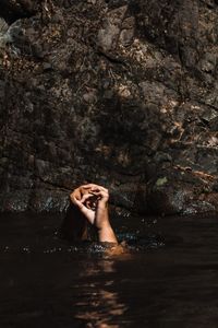 Cropped hands gesturing while swimming in lake