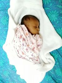 High angle view of baby sleeping in bed