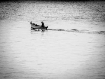 People in boat sailing on sea