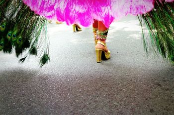 Low section of woman in carnival costume walking on street