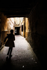 Rear view of woman walking in tunnel