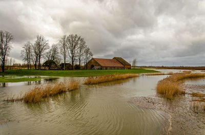 Rising water with a dike protecting a historic farm as part of the room for the river project